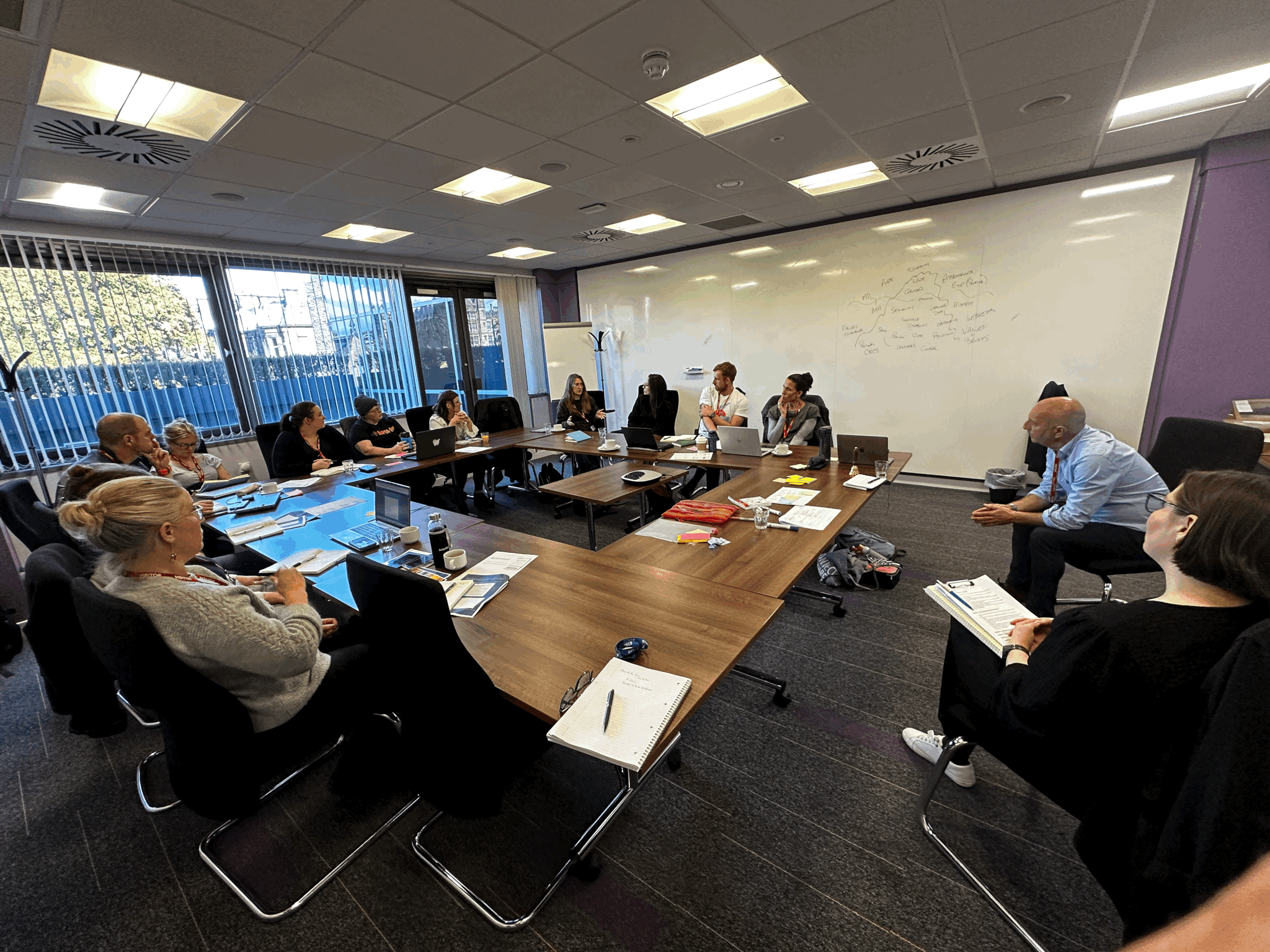 MPFG leadership workshop with participants engaged in collaborative learning around conference table